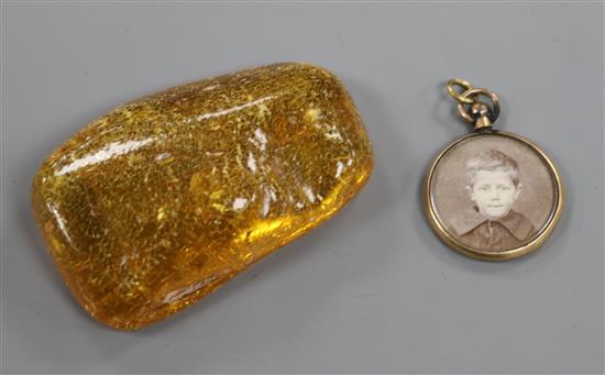 A circular yellow metal locket with photographic portrait and lock of hair verso and a piece of amber, approx 6 x 4cm